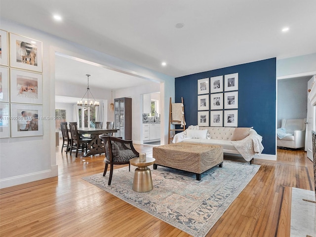 living room with light wood-type flooring and an inviting chandelier