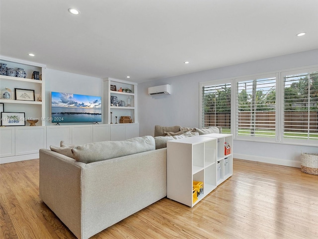 living room featuring a wall mounted AC and light hardwood / wood-style flooring