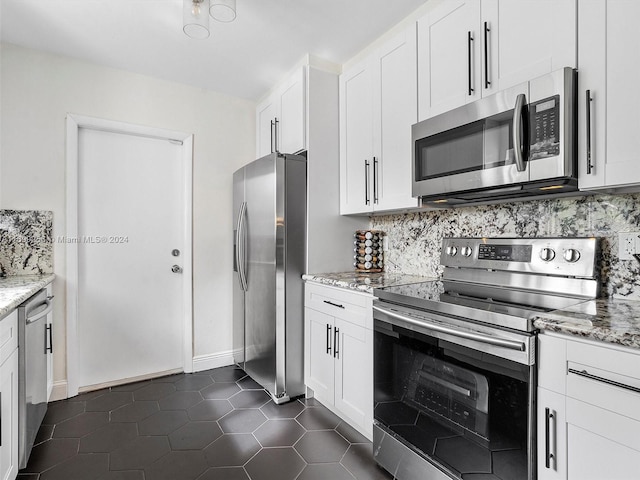 kitchen featuring decorative backsplash, light stone countertops, white cabinets, and appliances with stainless steel finishes