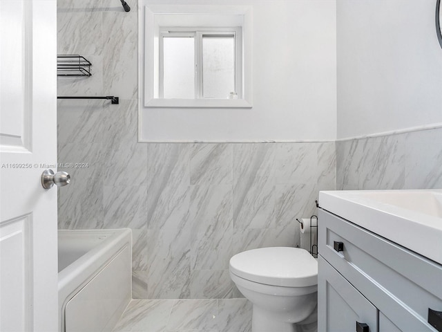 bathroom with vanity, toilet, and tile walls