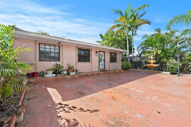 view of front of property with stucco siding and fence