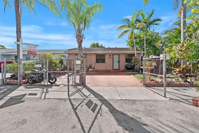 view of front facade with stucco siding, fence, and a gate