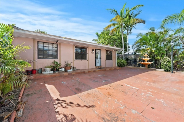 single story home featuring a patio, fence, and stucco siding