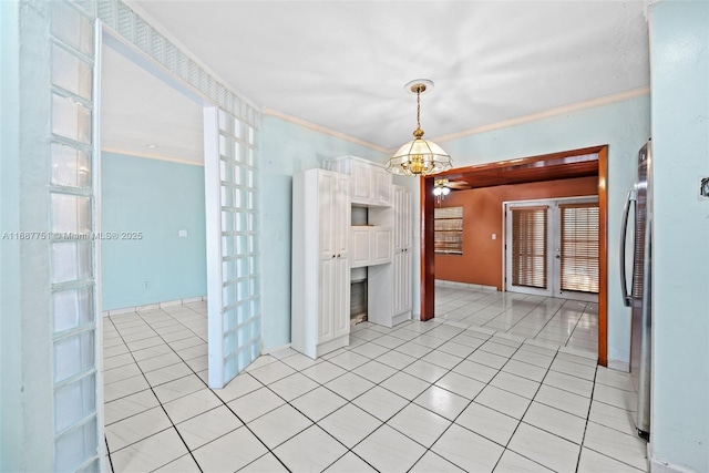 unfurnished room with an inviting chandelier, light tile patterned flooring, and ornamental molding