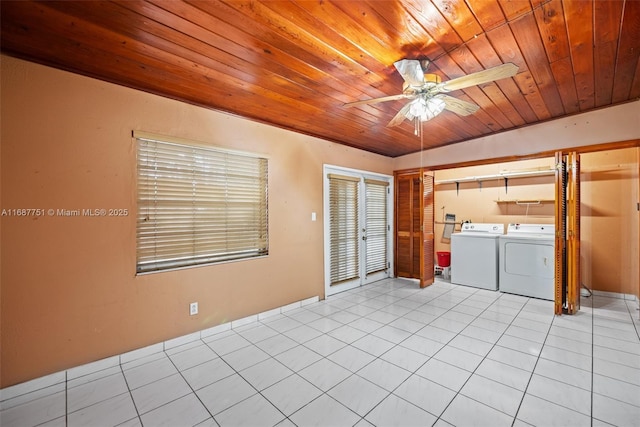 interior space with a ceiling fan, washing machine and clothes dryer, laundry area, tile patterned flooring, and wood ceiling