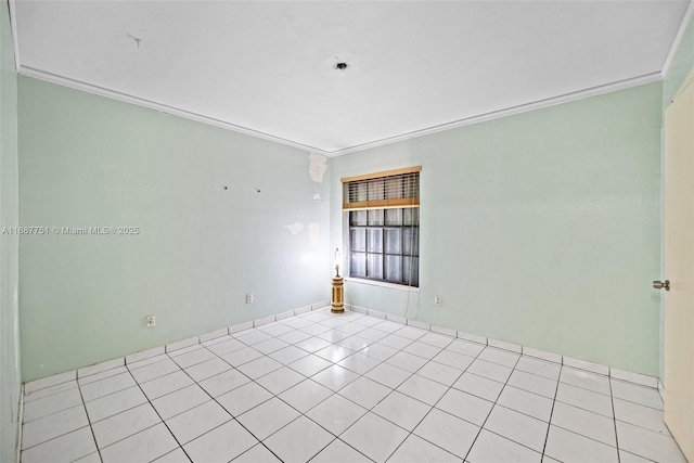 spare room featuring tile patterned floors and ornamental molding