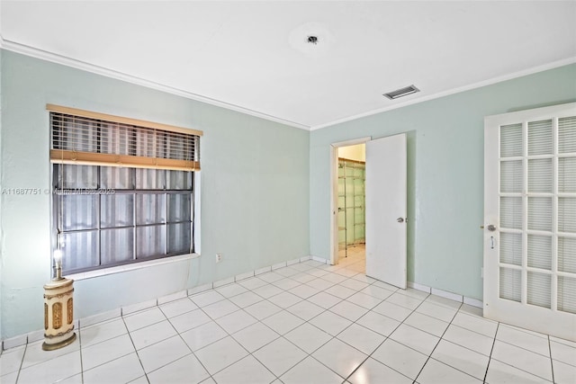 tiled spare room featuring visible vents and crown molding