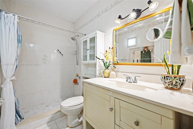 full bath with tile walls, toilet, tiled shower, and vanity