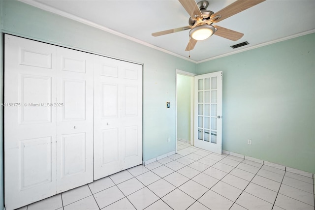 unfurnished bedroom featuring a closet, a ceiling fan, visible vents, and crown molding