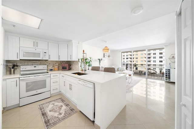 kitchen featuring white cabinets, decorative backsplash, white appliances, and kitchen peninsula