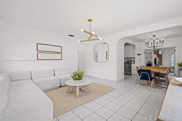 tiled living room with a notable chandelier