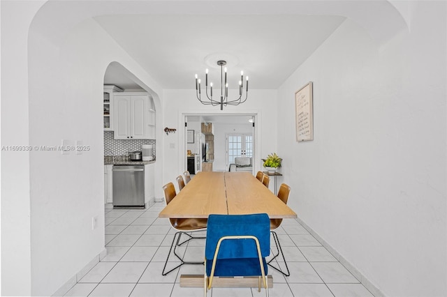 tiled dining room with an inviting chandelier