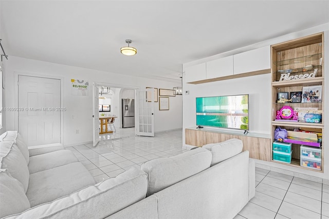 living room featuring french doors and light tile patterned floors