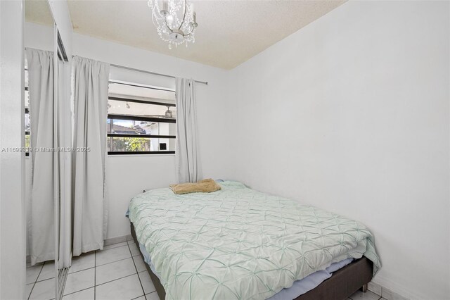 tiled bedroom featuring a notable chandelier