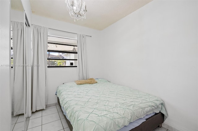 bedroom with light tile patterned floors and a chandelier