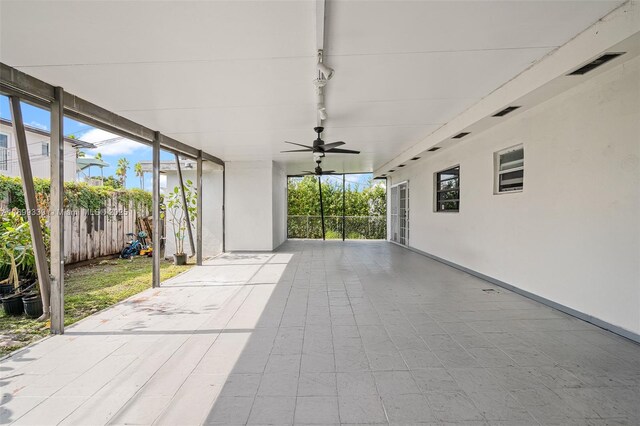 unfurnished sunroom with ceiling fan