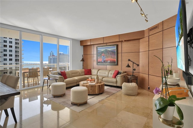 living room featuring expansive windows, a water view, and rail lighting