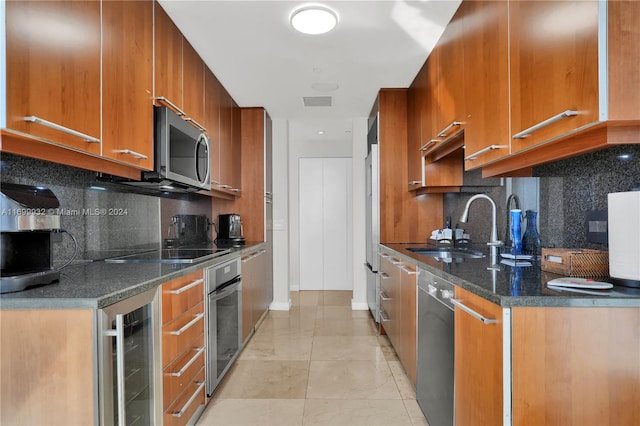 kitchen with sink, stainless steel appliances, wine cooler, dark stone countertops, and decorative backsplash