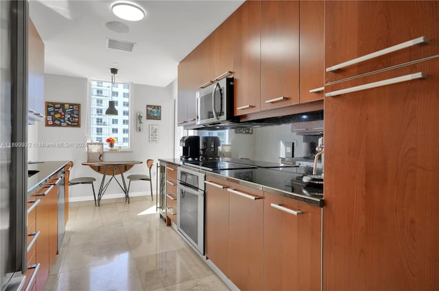 kitchen with appliances with stainless steel finishes and hanging light fixtures