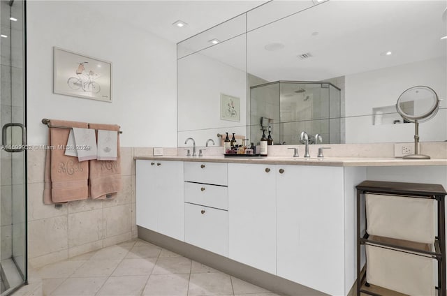 bathroom featuring tile patterned floors, vanity, tile walls, and walk in shower