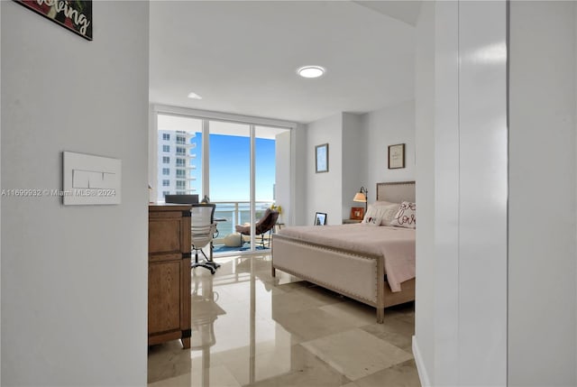 bedroom with a water view and a wall of windows