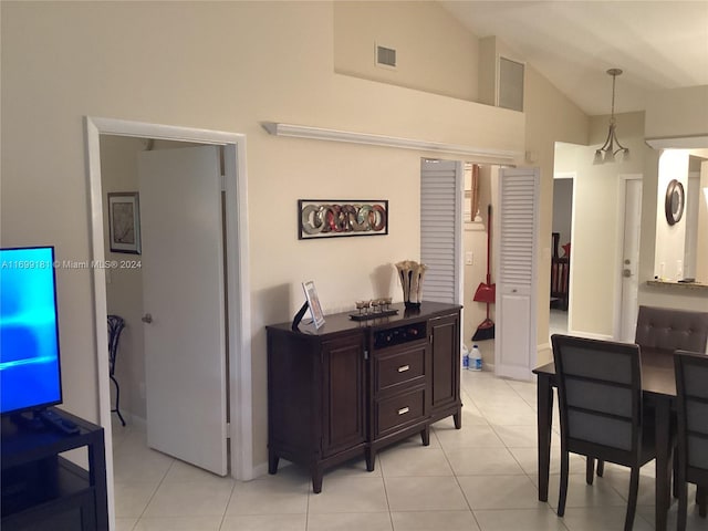 dining space with lofted ceiling and light tile patterned floors