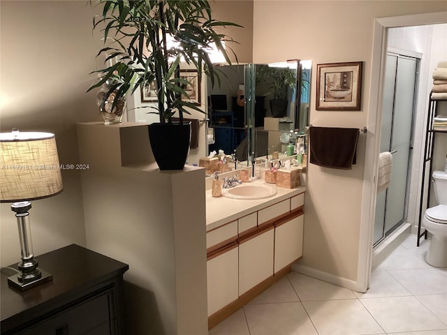 bathroom featuring tile patterned floors, vanity, toilet, and an enclosed shower