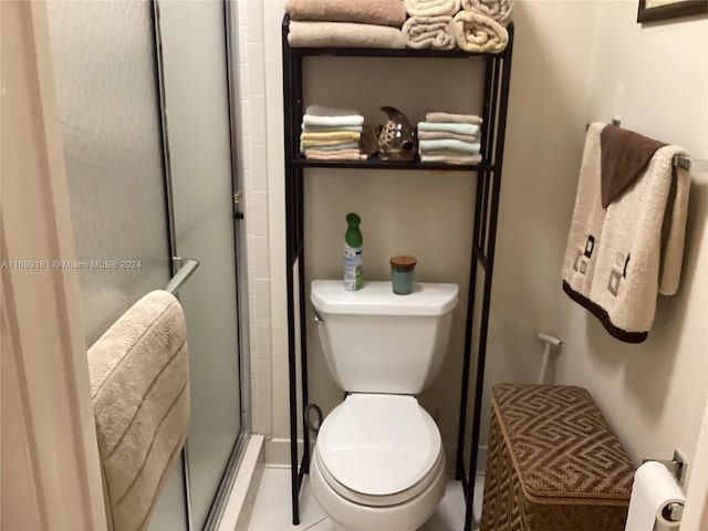 bathroom featuring walk in shower, tile patterned flooring, and toilet