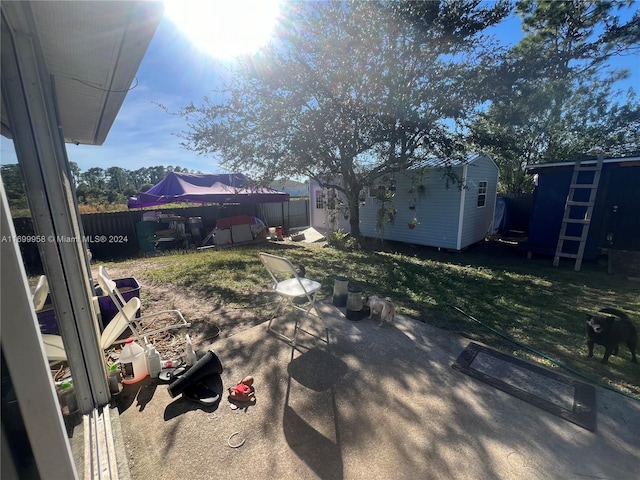 view of yard featuring a storage unit and a patio area