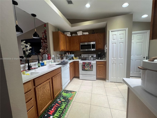 kitchen with light tile patterned floors, white appliances, decorative light fixtures, and vaulted ceiling