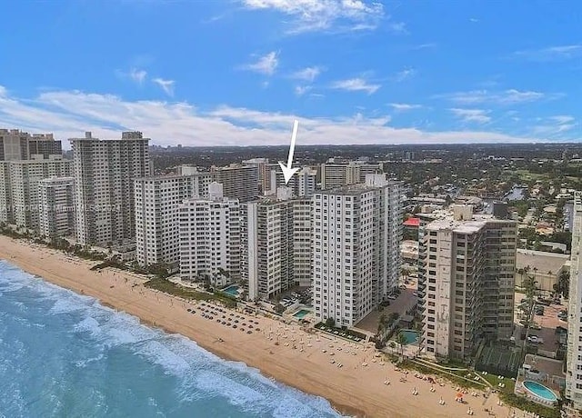 bird's eye view with a water view and a beach view