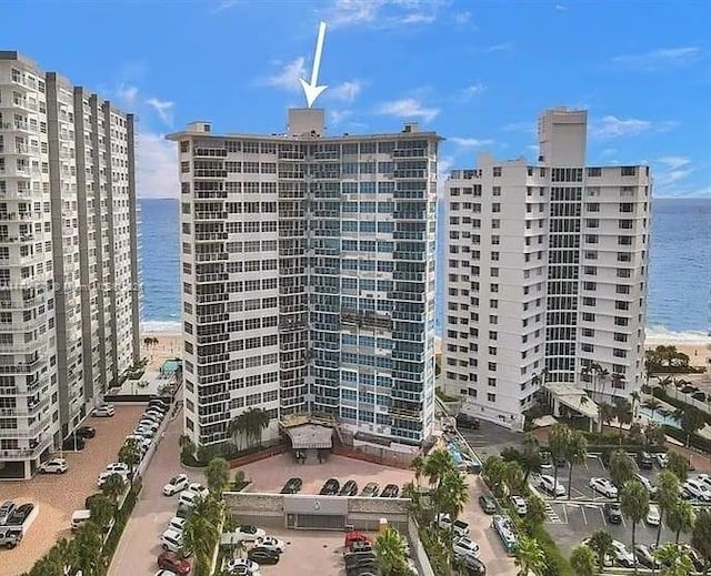 view of property with a water view and a view of the beach