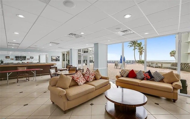 interior space featuring a paneled ceiling, a water view, and floor to ceiling windows