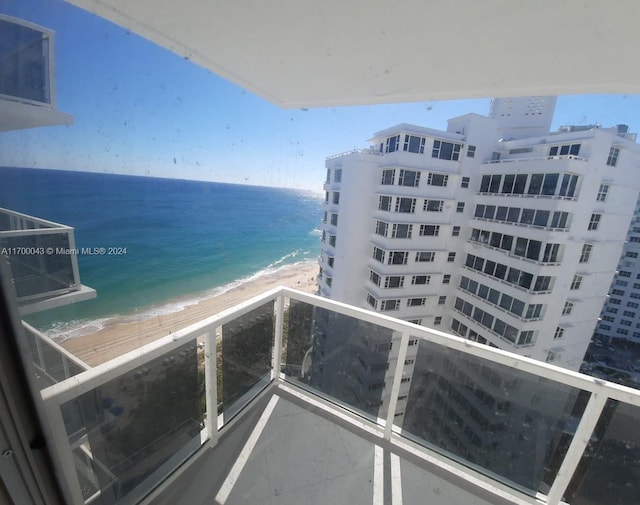 balcony featuring a water view and a view of the beach