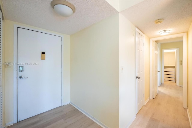 interior space featuring light hardwood / wood-style flooring and a textured ceiling