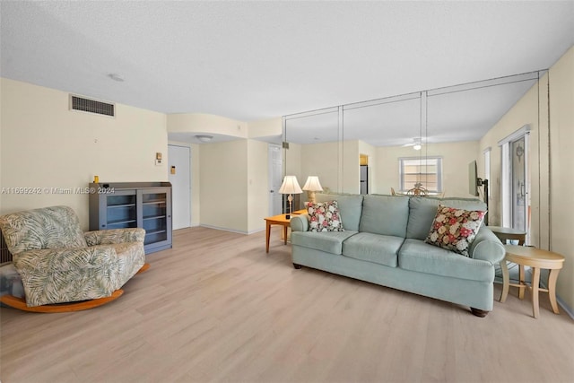 living room featuring a textured ceiling and light wood-type flooring