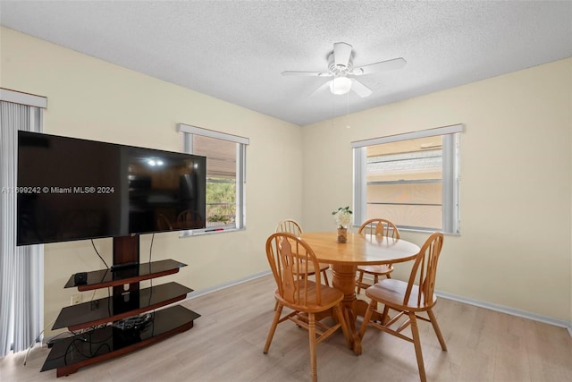 dining room featuring a textured ceiling, light hardwood / wood-style floors, and ceiling fan