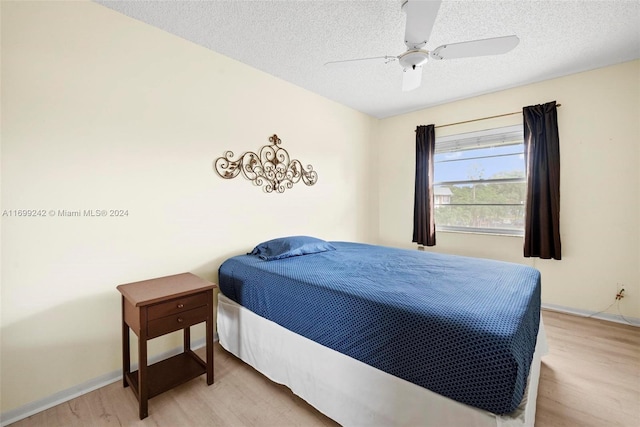 bedroom featuring hardwood / wood-style floors, ceiling fan, and a textured ceiling