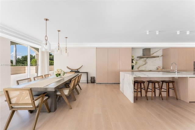 dining space with sink and light hardwood / wood-style floors