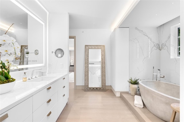 bathroom with vanity, a washtub, and wood-type flooring