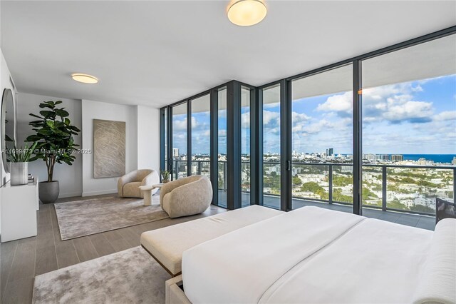 500 Alton Unit 2405/06, Miami Beach, FL 33139 - bedroom featuring a water view, expansive windows, a city view, baseboards, and wood finished floors