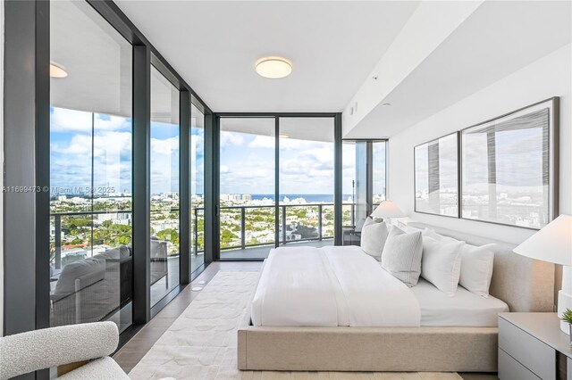 500 Alton Unit 2405/06, Miami Beach, FL 33139 - bedroom with a view of city, access to exterior, wood finished floors, and floor to ceiling windows