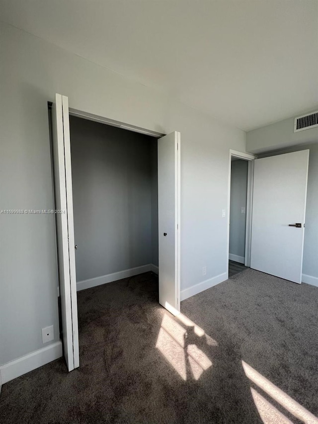 unfurnished bedroom with dark carpet