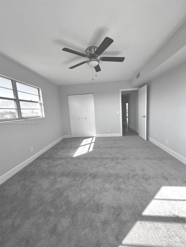 unfurnished bedroom featuring carpet, a closet, and ceiling fan