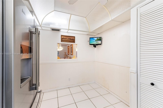 basement featuring wooden walls and light tile patterned flooring