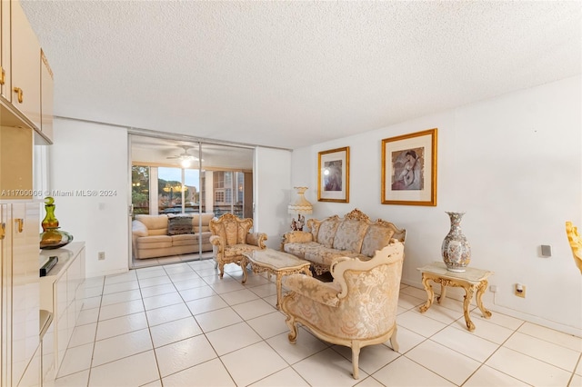 living room featuring ceiling fan, light tile patterned floors, and a textured ceiling