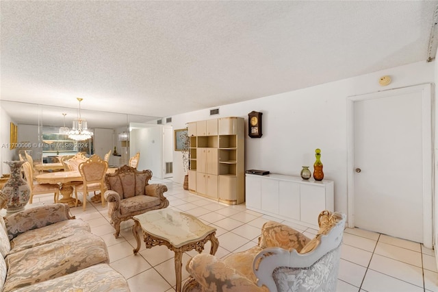 living room featuring light tile patterned floors, a textured ceiling, and an inviting chandelier