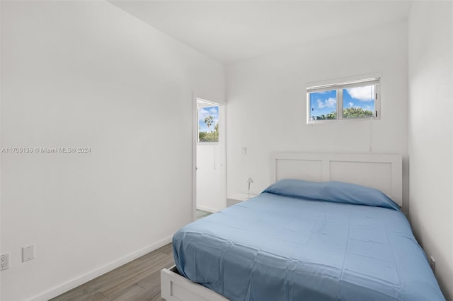 bedroom with wood-type flooring and multiple windows