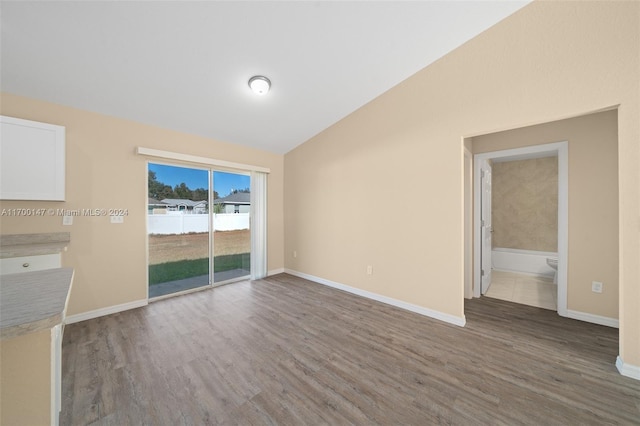 unfurnished living room featuring hardwood / wood-style floors and lofted ceiling