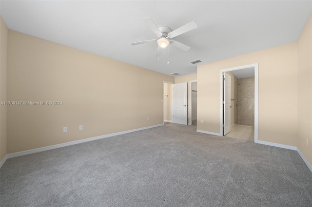 unfurnished bedroom featuring ensuite bath, ceiling fan, and light carpet